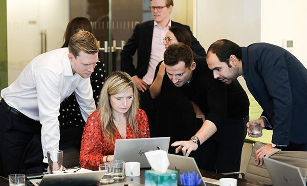 Four employees brain storming around a desk